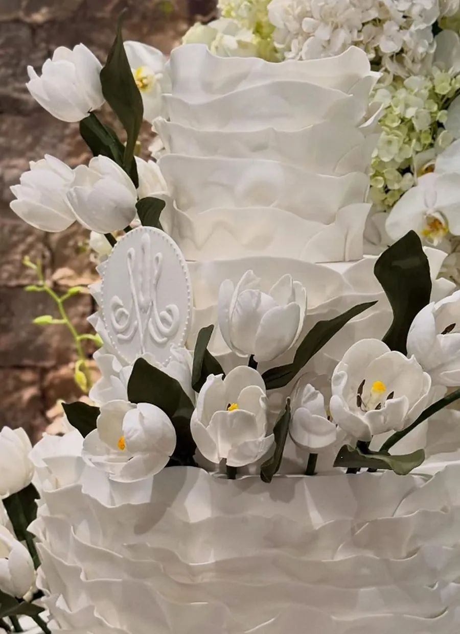 Detalhe de bolo branco com babados e tulipas de açúcar